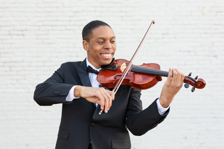 Union High School Senior playing the violin during his senior photoshoot expierence