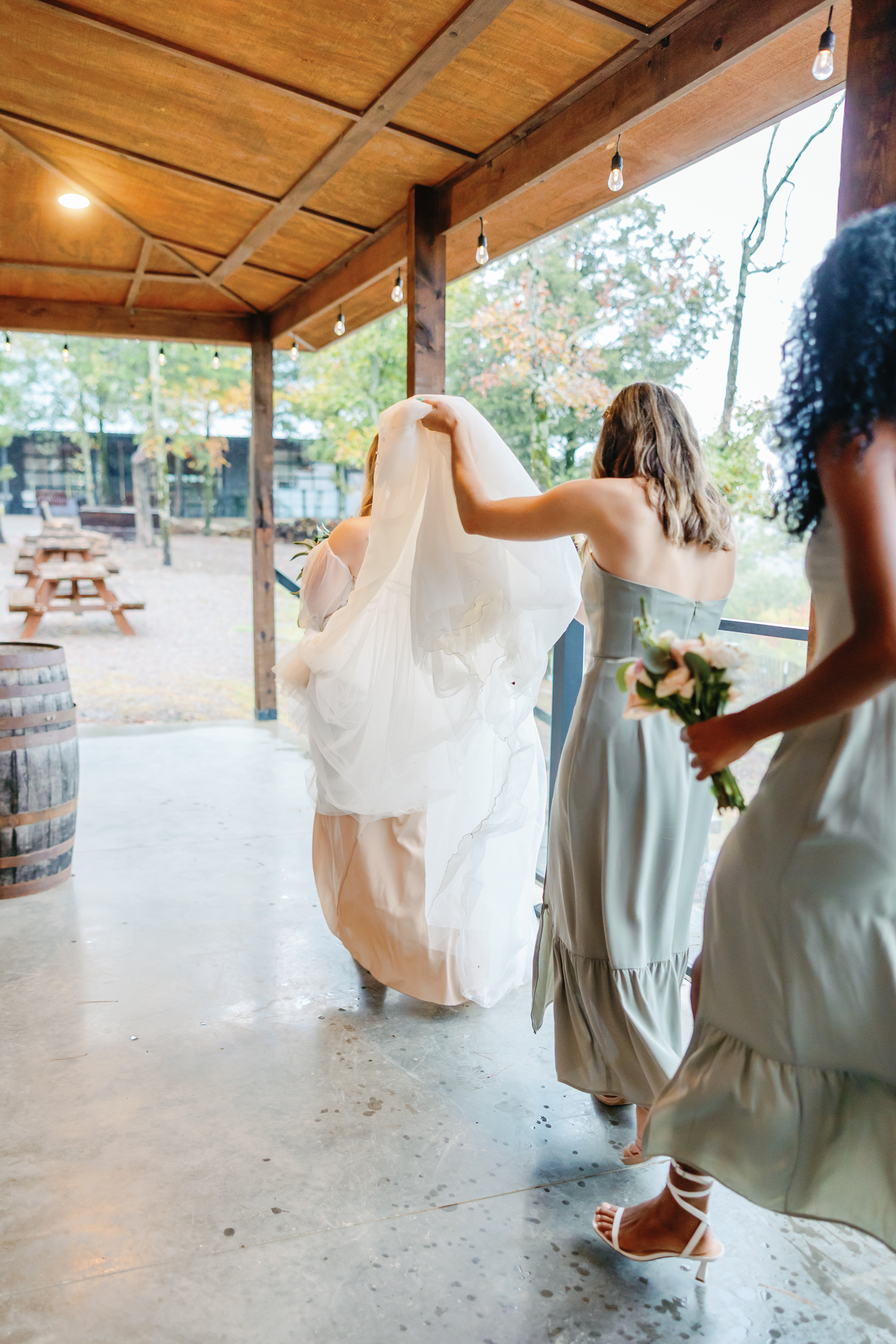 bridesmaids carrying the brides train, keeping ti out of the rain