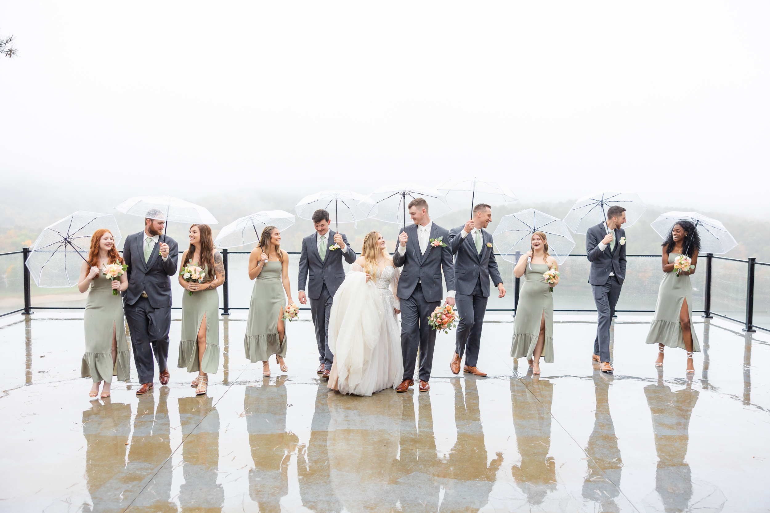 bridal party walking in the rain with clear umbrellas for bridal party portraits