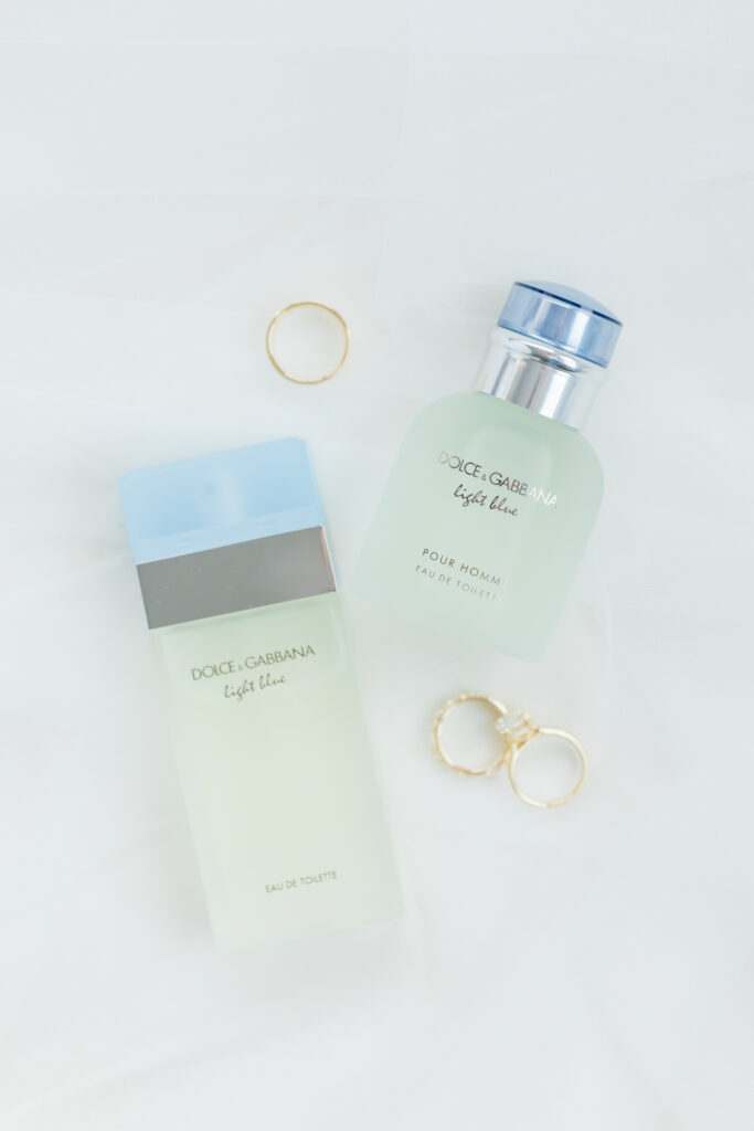 detail photo of bride and grooms rings with their perfume and cologne