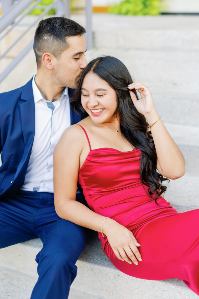 he's kissing her head while sitting on the stairs