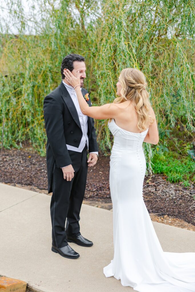 bride wipes away grooms tear at first look